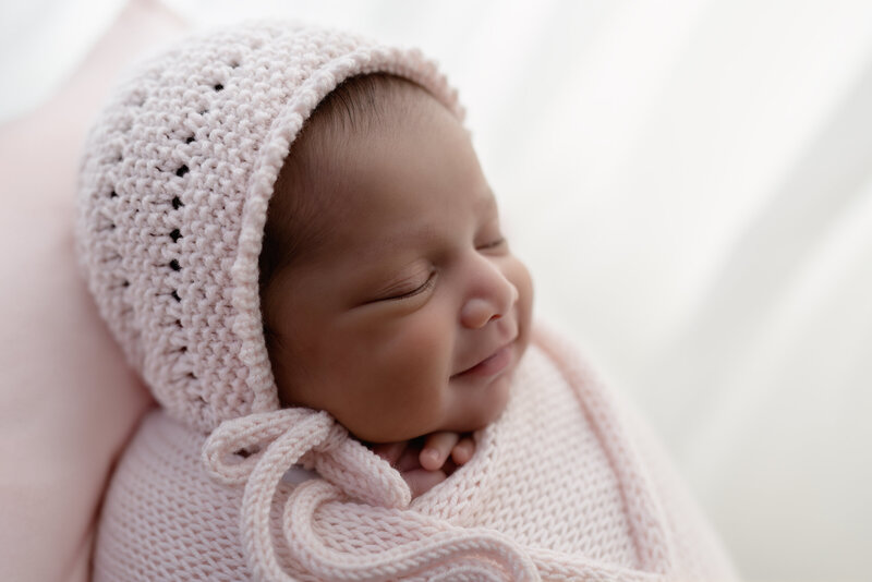 A rare and heartwarming newborn smile—wrapped in soft textures and joy.