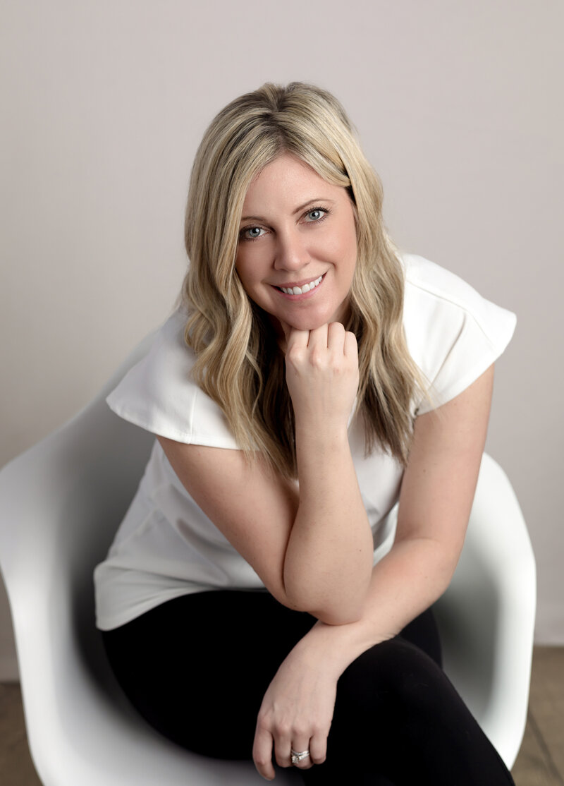 female in white shirt sitting for studio headshot 