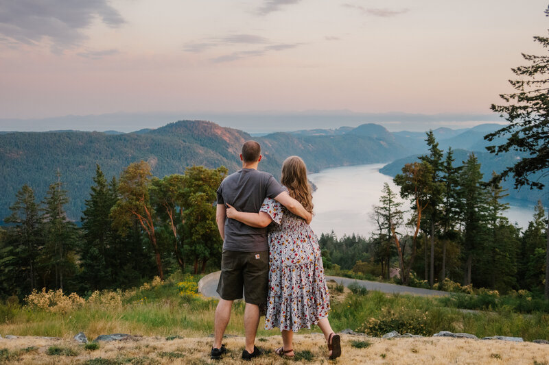 Laura-Anne and her husband from the back with their arms around each other in front of a mountain landscape