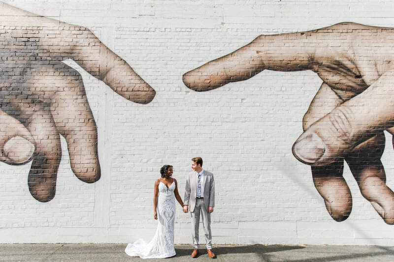 wedding couple standing in front of mural wall