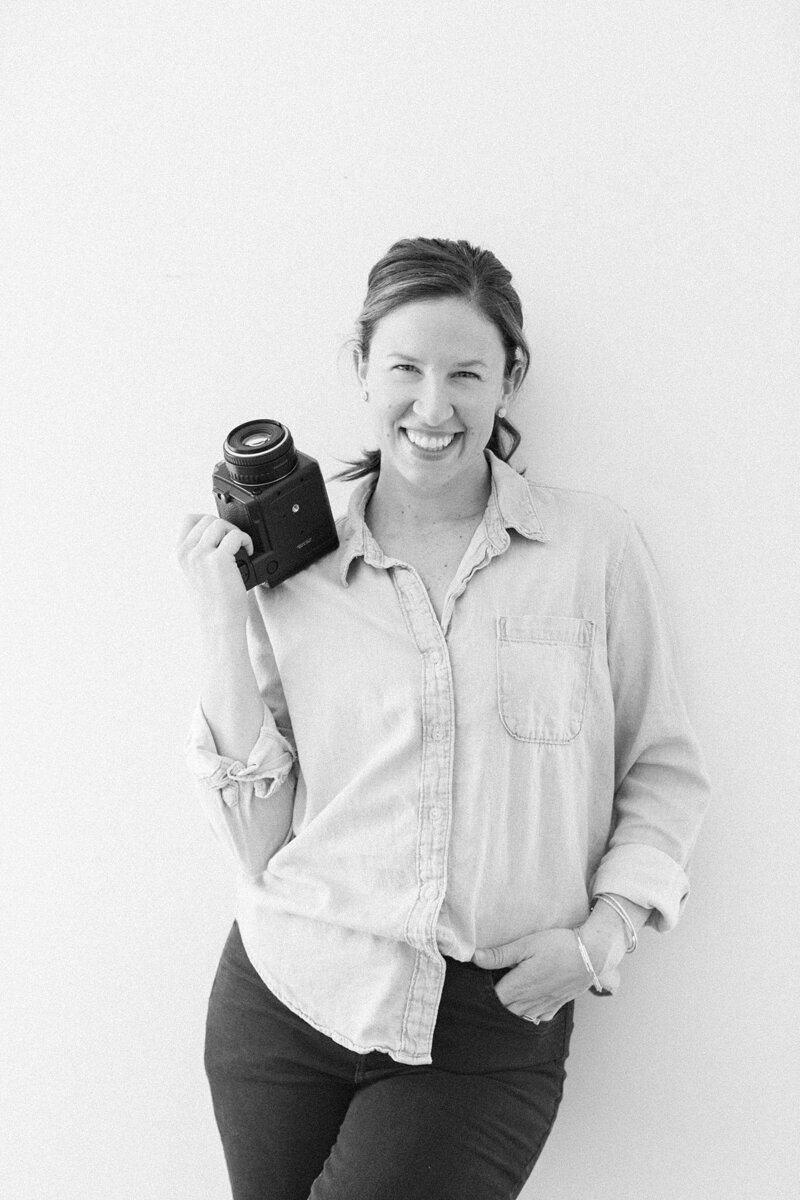 black and white photo of Brittany Thomas holding film camera