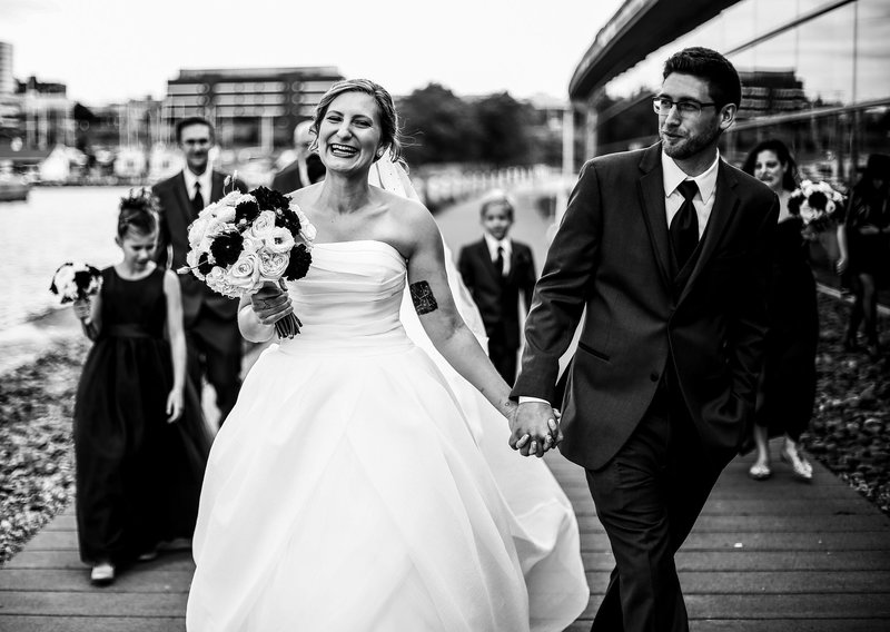 bride and groom walk around the BIcentennial Tower