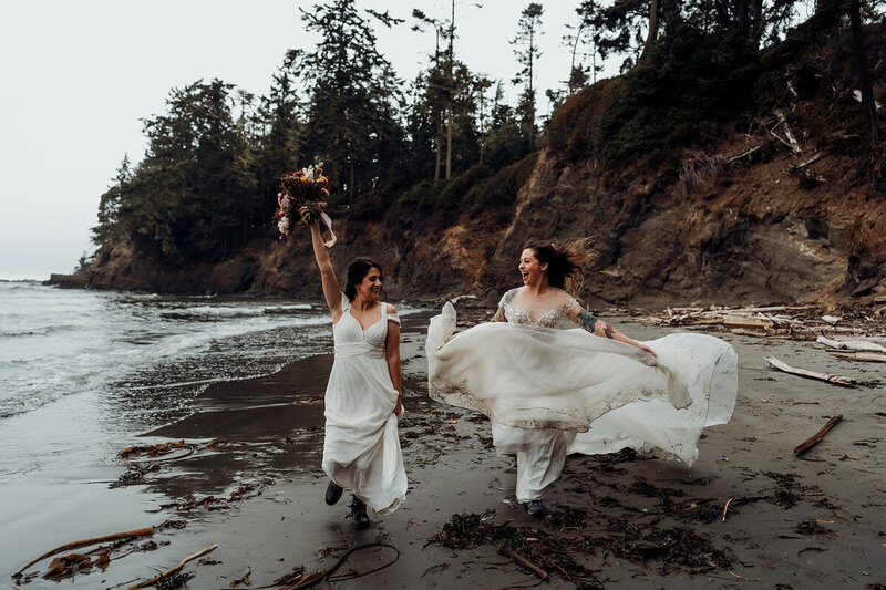 brides frolic across the beach after elopement in Washington