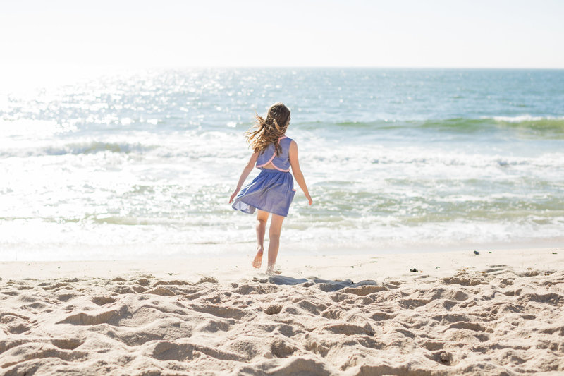 girl walking towards the water on the beach