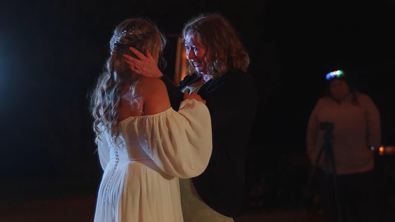Mother of bride embracing bride intimately while she cries