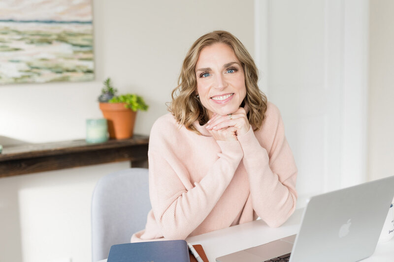Stephanie smiling in her office with her hands gently folded under her chin