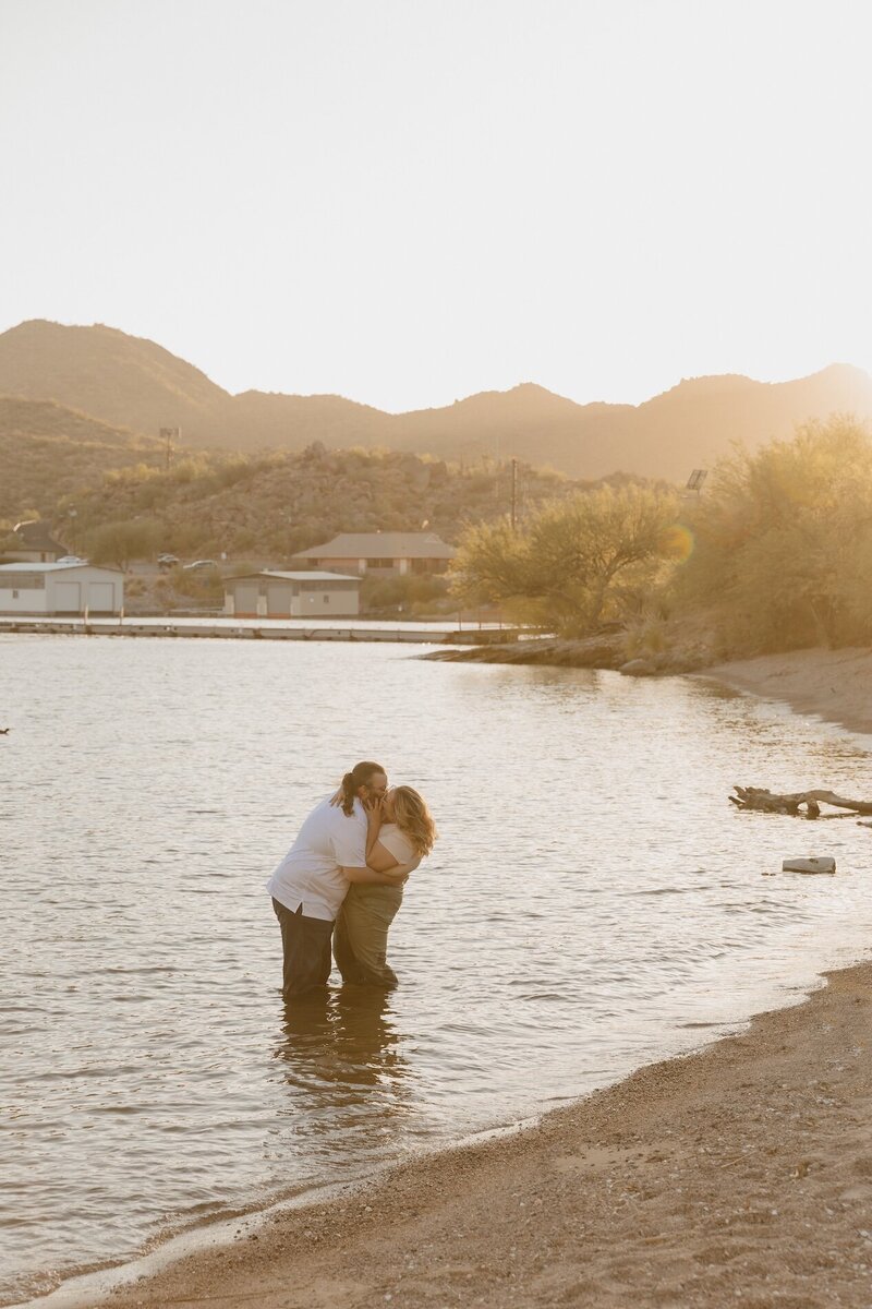 couple kisses in lake for couples photoshoot in arizona