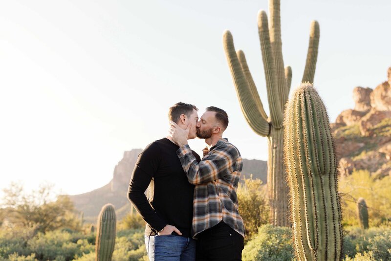 Two grooms kiss in the Superstition Mountains for their engagement photos.