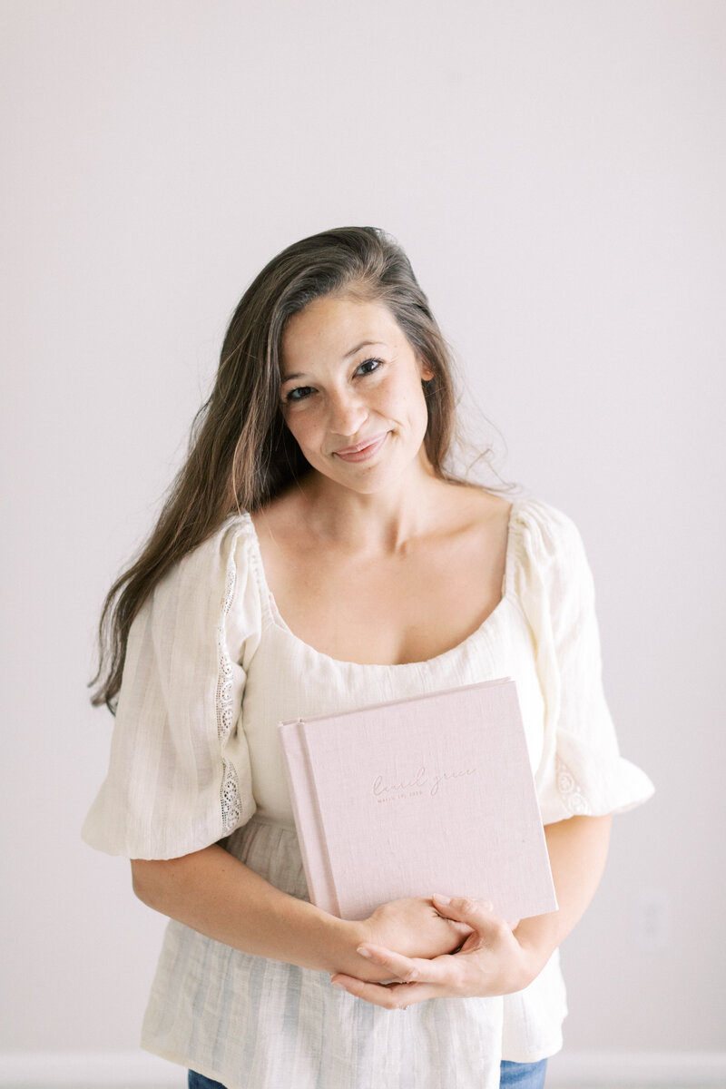 photo of photographer in madison wi, Talia Laird Photography holding an album for her clients