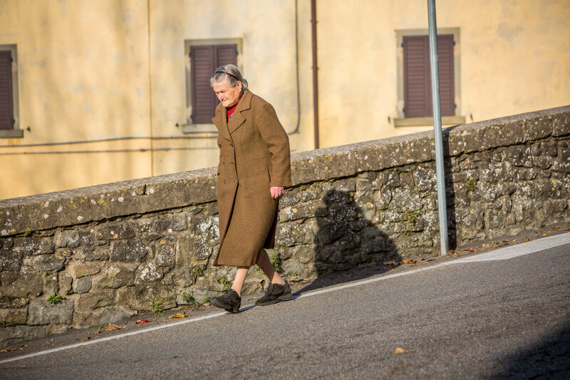 woman walks down street Cortona, Italy