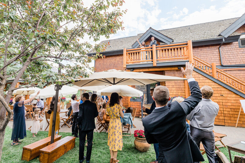 A warm moment captured as the bride and groom wave to their guests from the balcony at The Baron Bison Inn during their wedding reception.