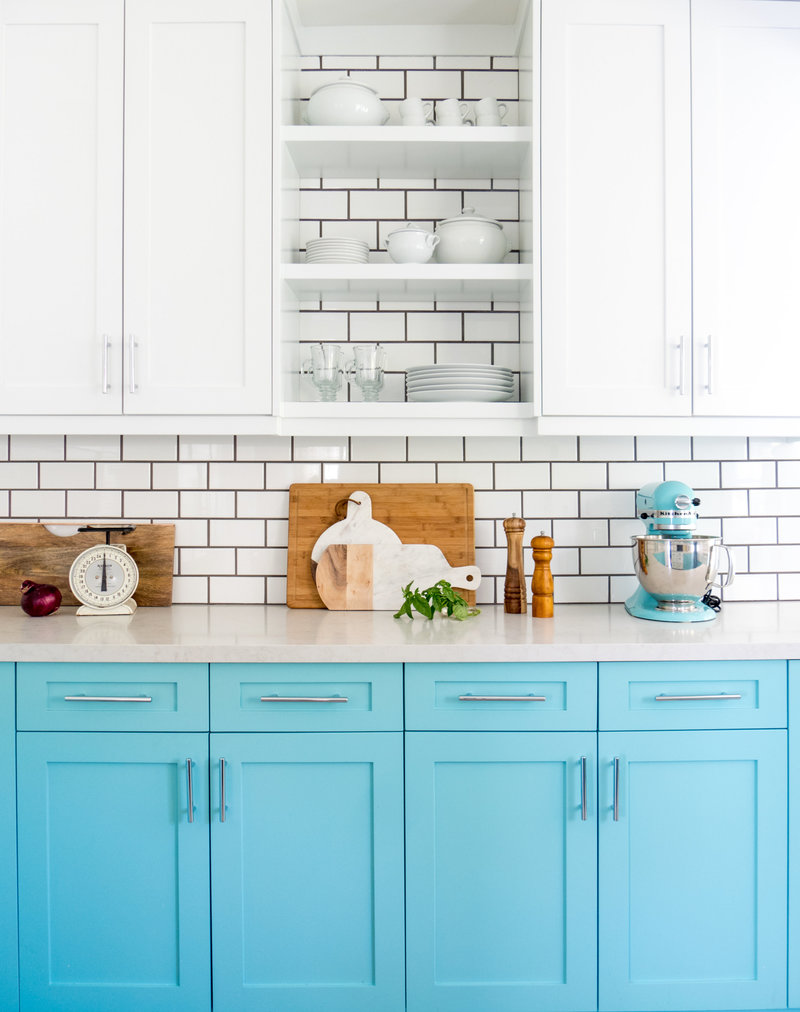 Kitchen with blue lowers, white uppers, and subway tile with black grout