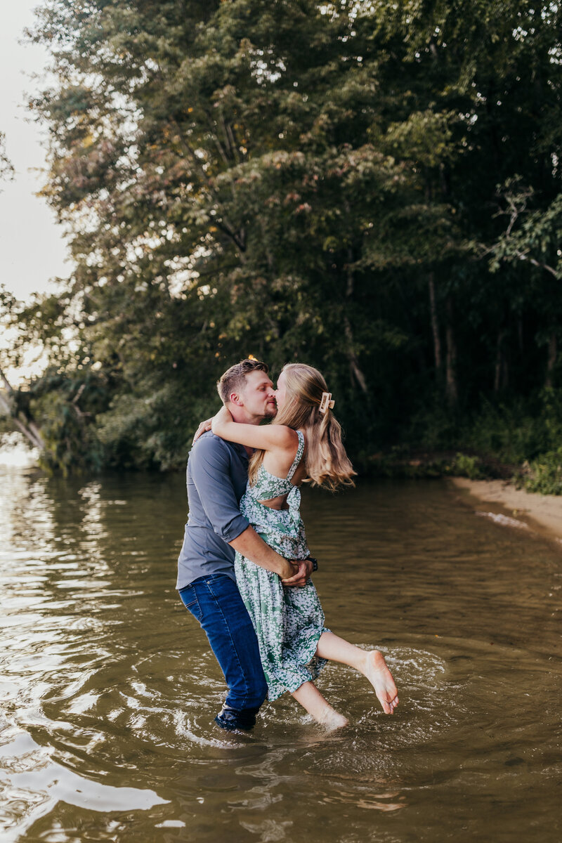 young blonde couple playfully embraces in the water at Melton Hill Park in Knoxville