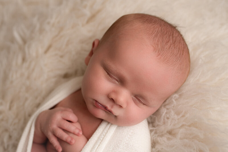 Fond du Lac Newborn Photo sleeping on white props in studio | Glory Be Photo by Tara Bos