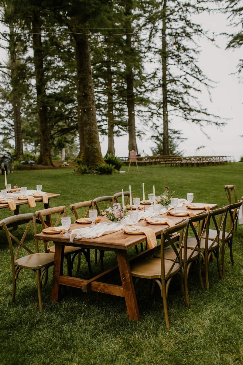 A farmhouse table and chairs with table settings, representing Oregon party and event rentals by Birdie June.