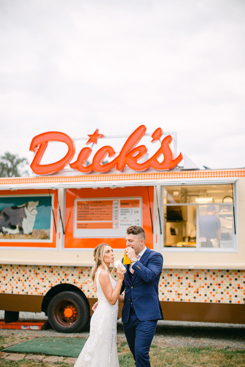 bride and groom in front of a Dick's food truck 
