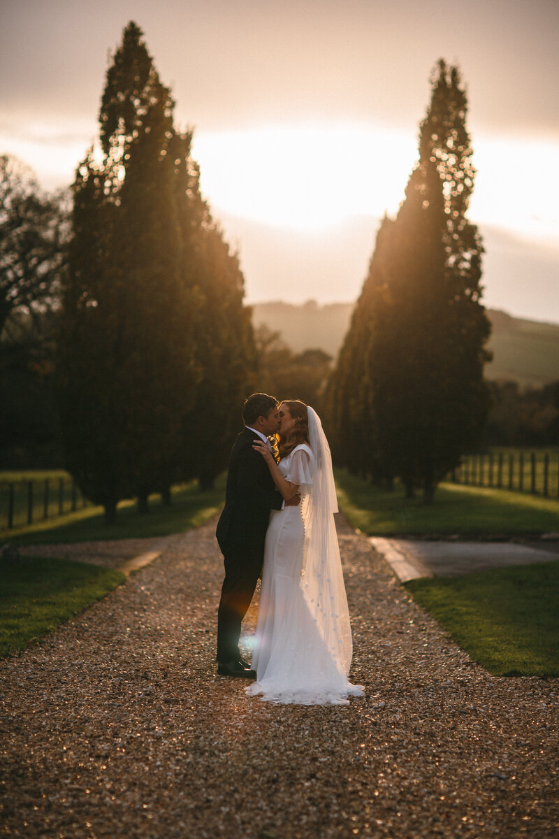 Couple kiss on driveway at Pynes House in Devon 