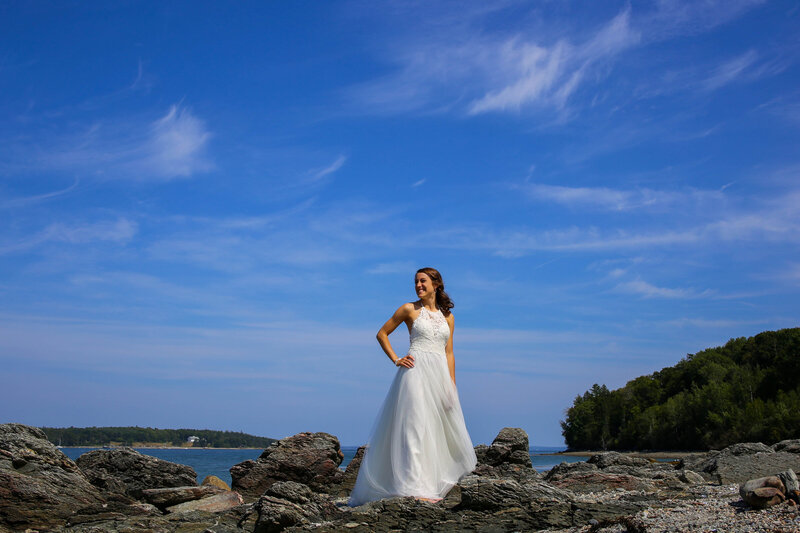 Bride standing on rocky beach | Taken by Bar Harbor, Maine Wedding Photographer (who photographs in Maine and beyond)