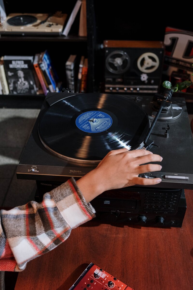 woman placing vinyl on a record player