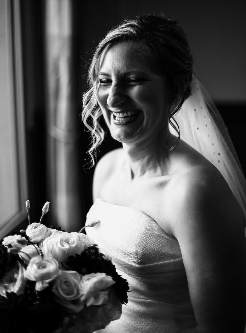 Bride laughing in solo portrait before her Sheraton Erie Bayfront Hotel wedding