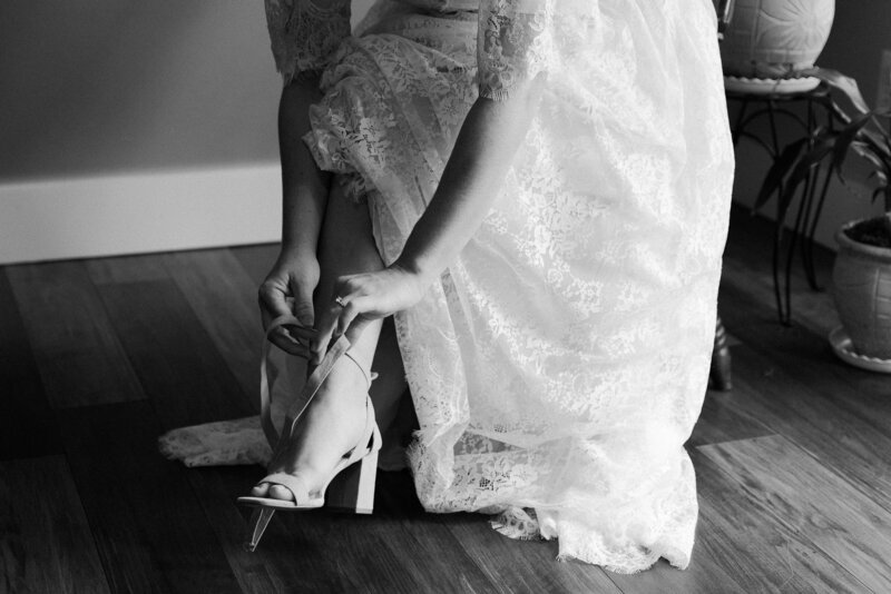 Getting ready photos before the wedding day, bride putting on her wedding day shoes