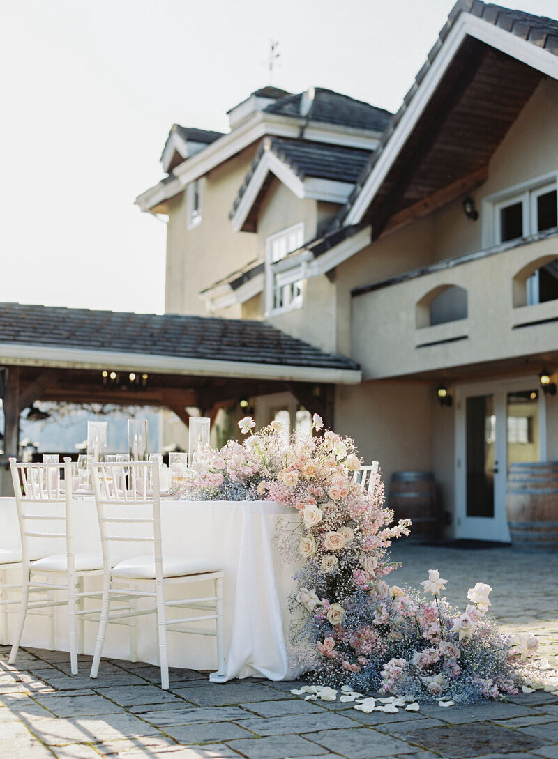Romantic outdoor sweetheart table with cascading pastel florals