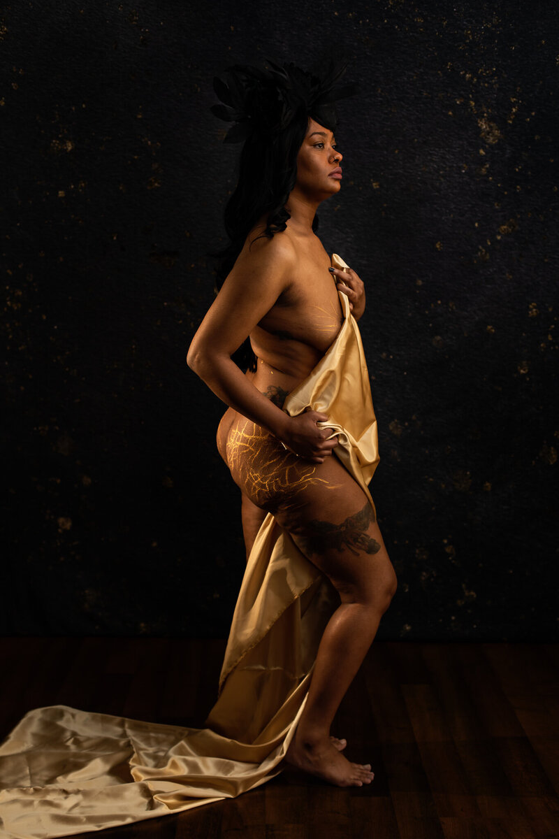 A beautiful black woman grabs her bra strap and stares at the camera while pulling on her bra strap