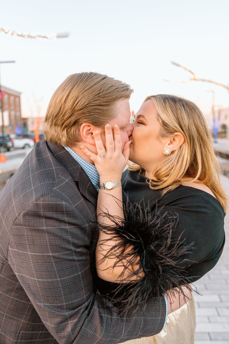 couples engagement session downtown with husband and wife kissing