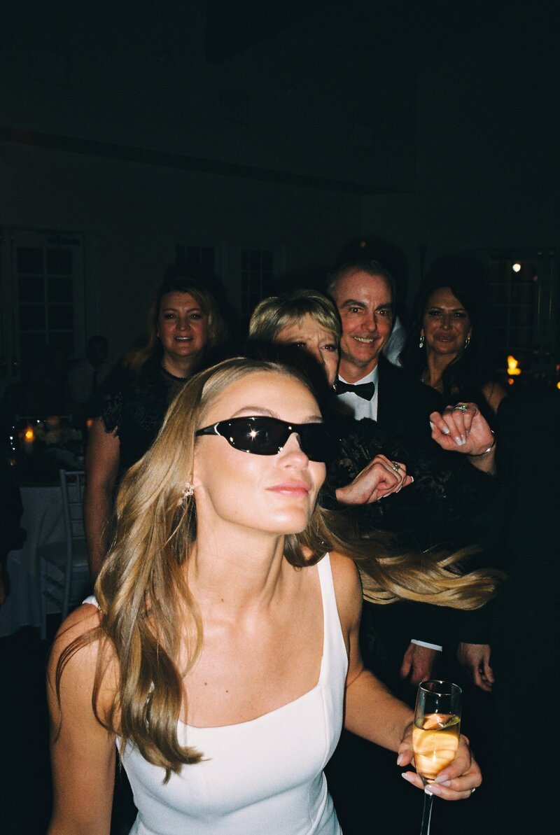 Bride wearing sunglasses at wedding reception