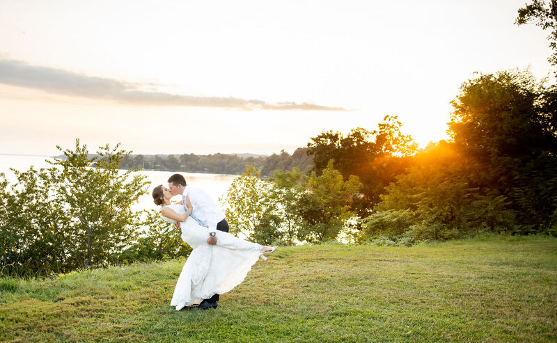 Groom dips bride next to the water at Bohemia Overlook, Maryland Wedding