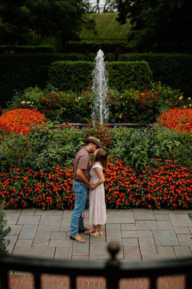 Romantic engagement session of a couple in a flower-filled garden park in New York City, captured by NYC wedding and elopement photographer Dom Augustine.