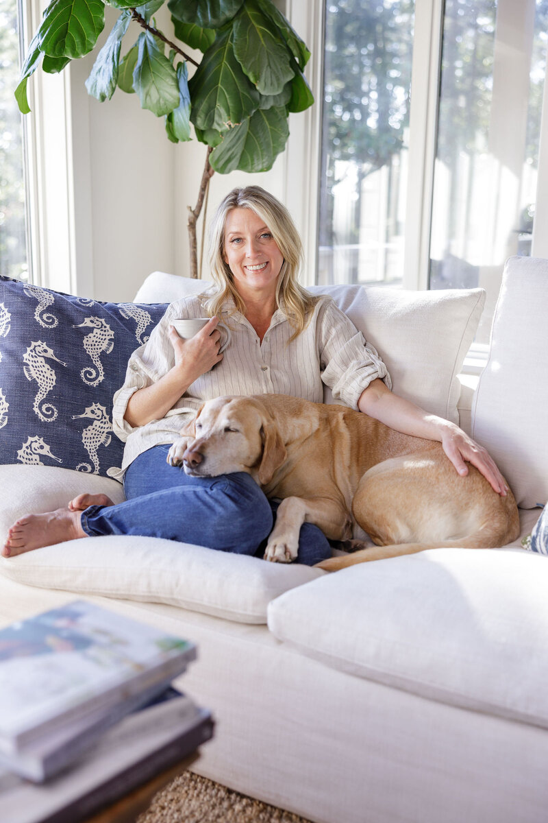 Kat, functional medicine health coach, sitting with her dog, highlighting the connection between oral health and overall wellness.