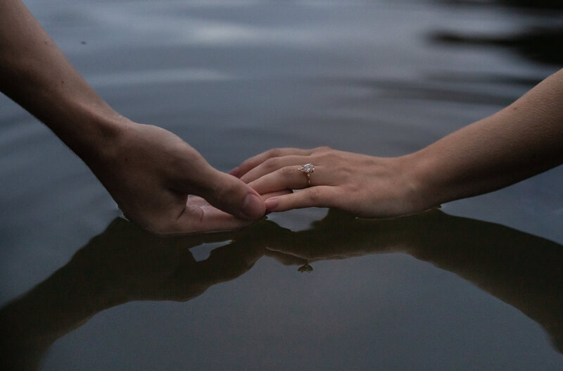 A photo of an engaged couple showing their ring in the sand in Cannon Beach, Oregon. Photo taken by Kollar Photography. Arizona Elopement Photographer