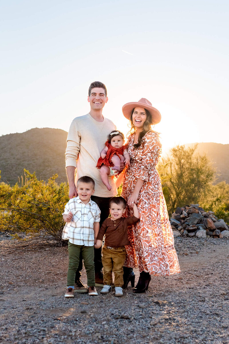 arizona mom with two daughters hugging her maternity belly in lake pleasant for photography session