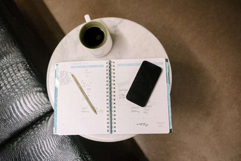 Calendar sitting on a marble table next to a cup of coffee