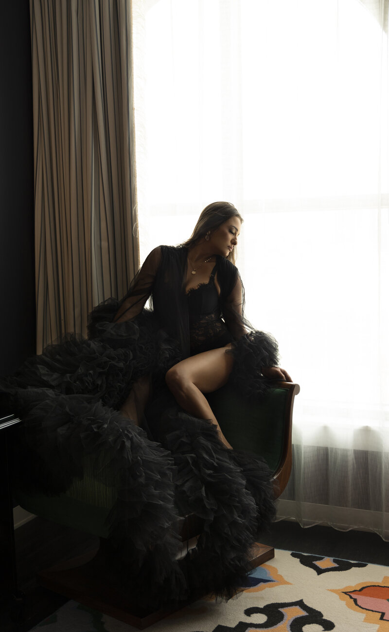 Woman standing in natural light wearing a bodysuit during a boudoir session in Nashville