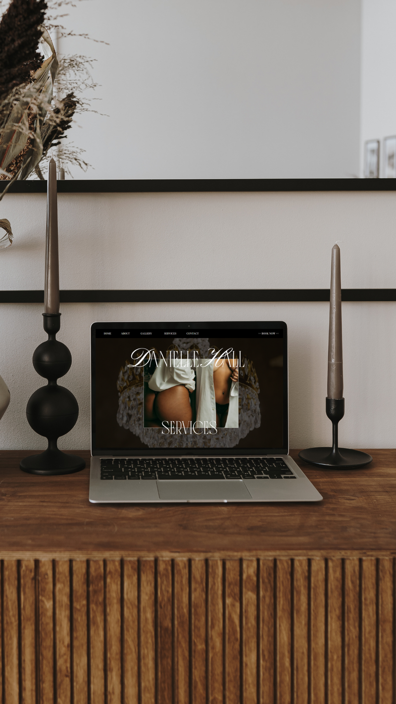 A poster depicting an elopement photographer website homepage resting on a deep sienna colored leather couch