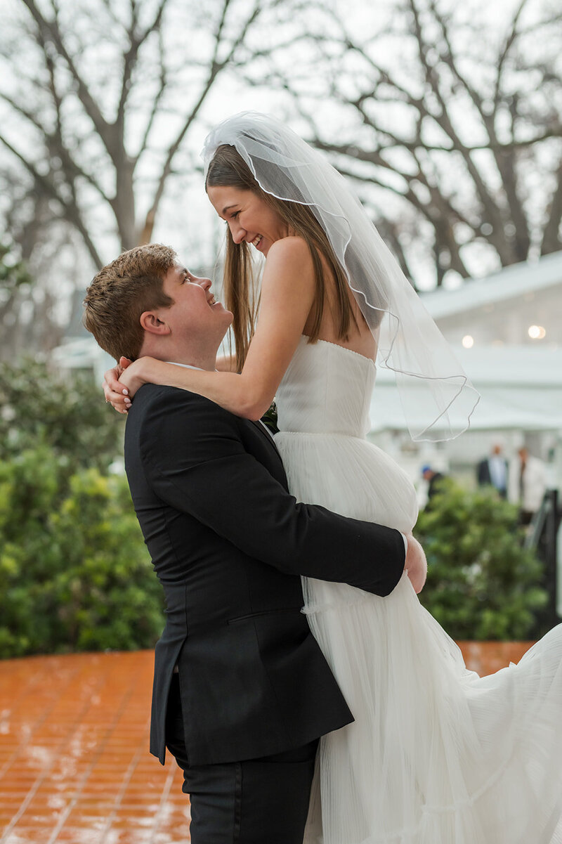 Groom lifting his bride during an emotional moment on their wedding day, planned by an Austin wedding planner known for heartfelt, joyful events.