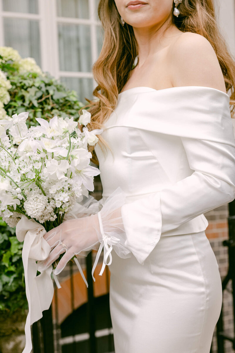 A wedding day photo of the bride in her white dress holding her white bouquet of flowers in London the United Kingdom