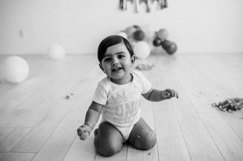 baby sitting on floor smiling