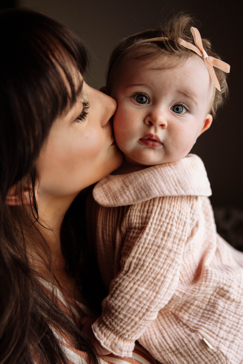 Mama kissing baby's cheek