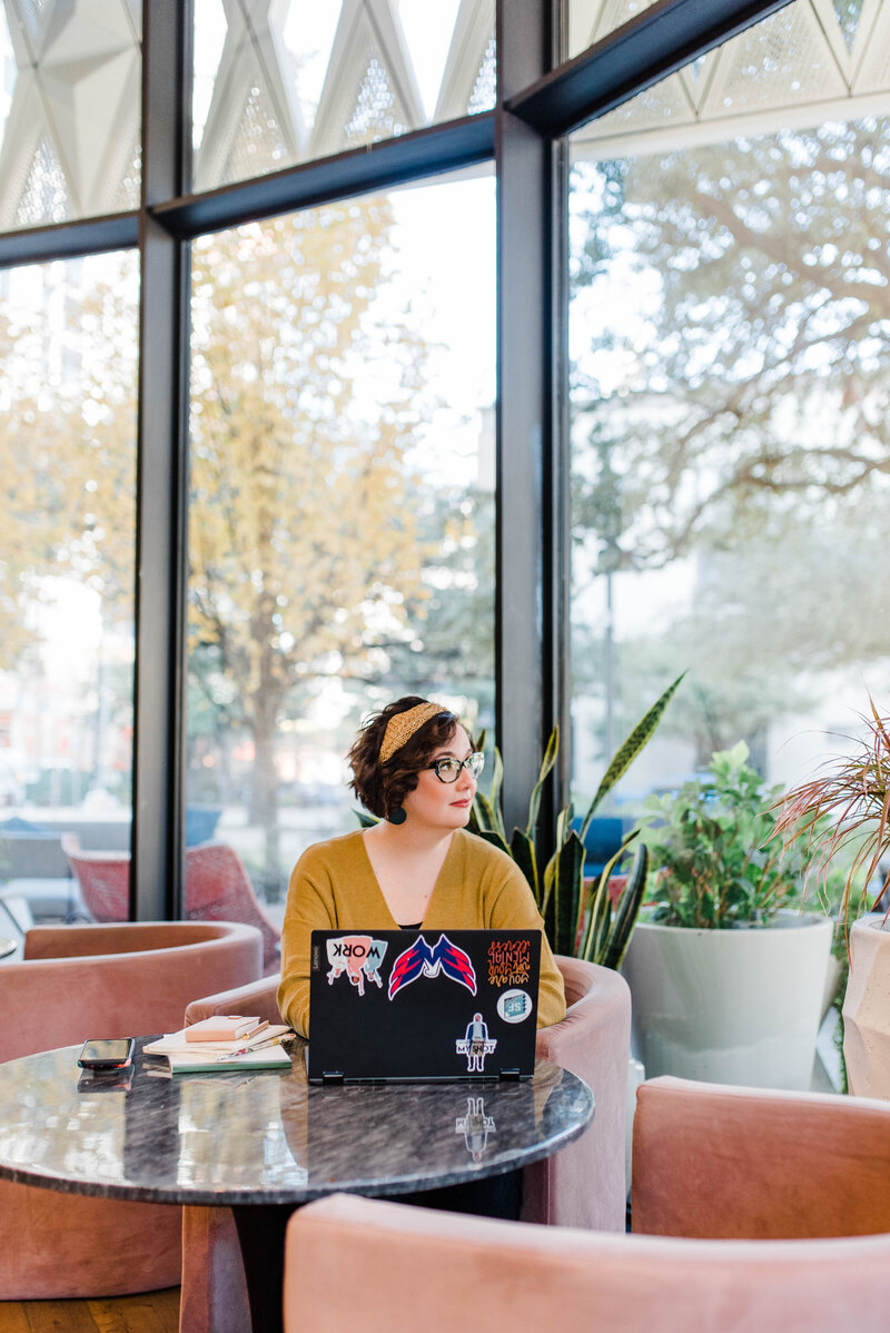 Copywriter Sara Gillis wears a yellow sweater and looks outside