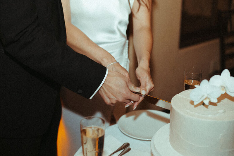 A bride and groom cut their wedding cake during their reception in San Francisco