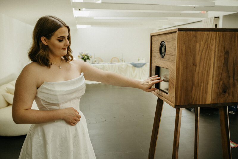 A bride selects a photo on a rented photo booth. 