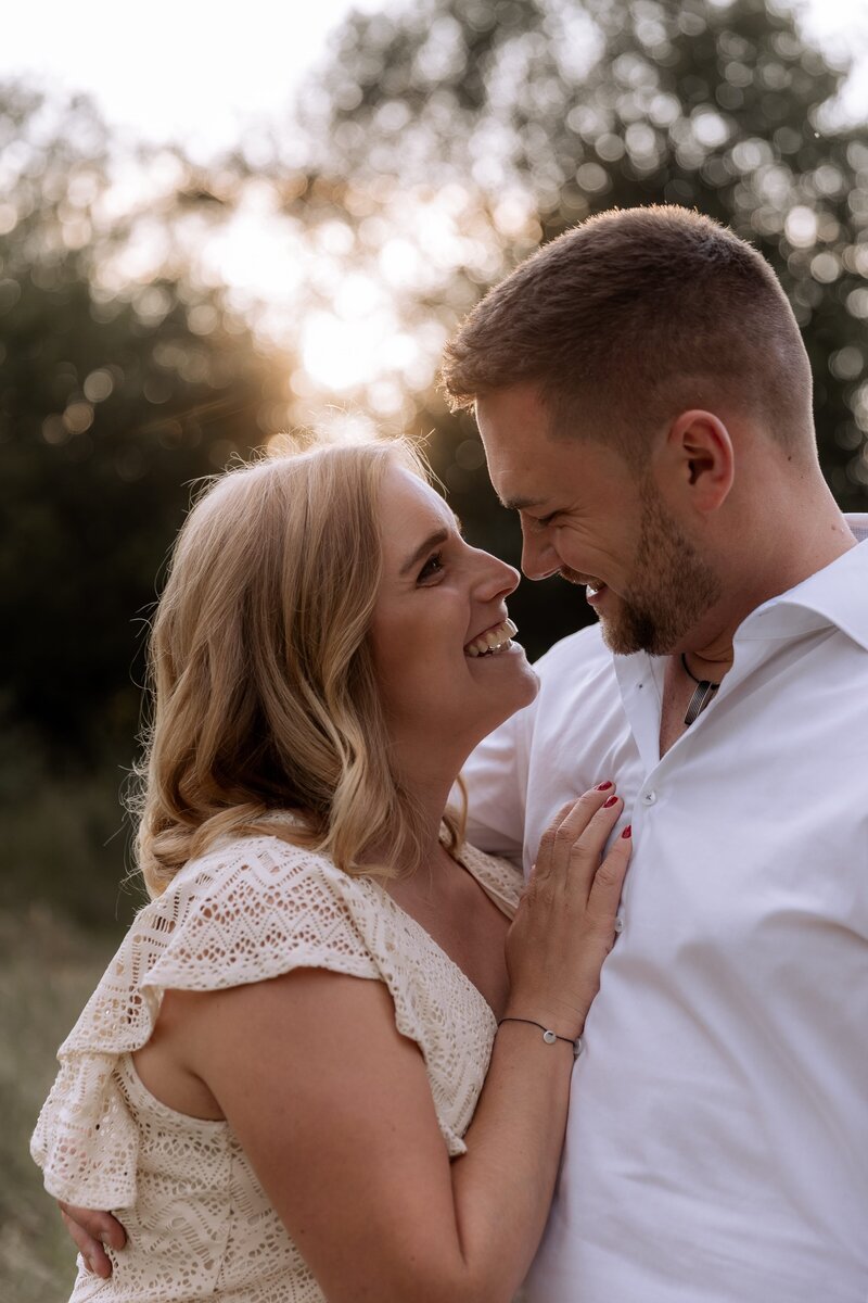 Mann und Frau stehen nah aneinander und lachen sich an