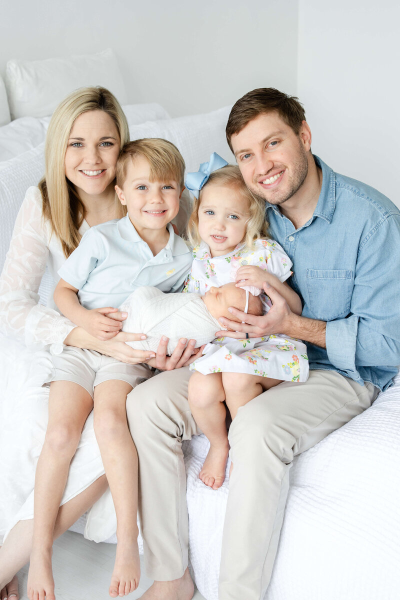 Family of 4 smiling at camera