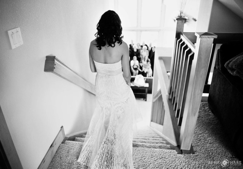 Bride walks down the grand staircase inside a private rental home in Estes Park CO