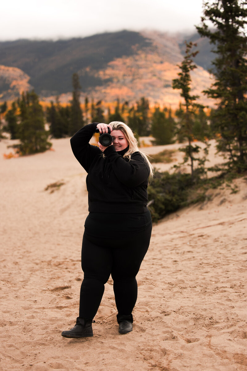 edmonton photographer holding a camera on the beach