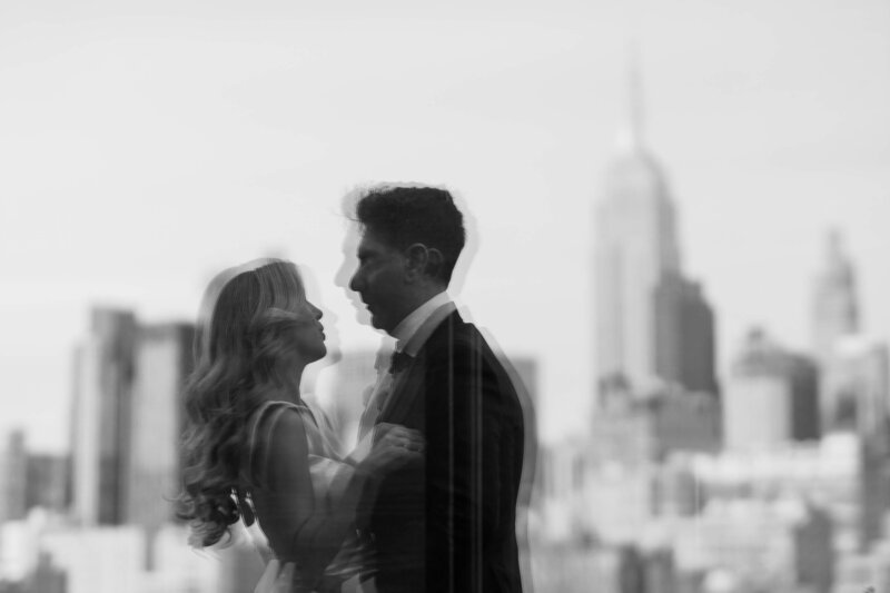 Black and white image of a couple overlooking the NYC skyline during their wedding day first look