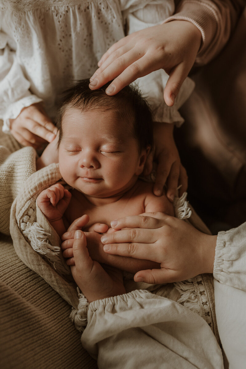 newborn baby wrapped bundle blankets hands hugging